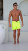 Man in yellow swim trunks posing.