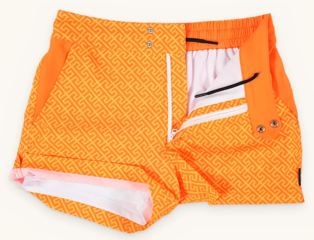 Luxe swim trunks laid flat, front button and zip closure open to show the inner compression liner and hidden drawstring